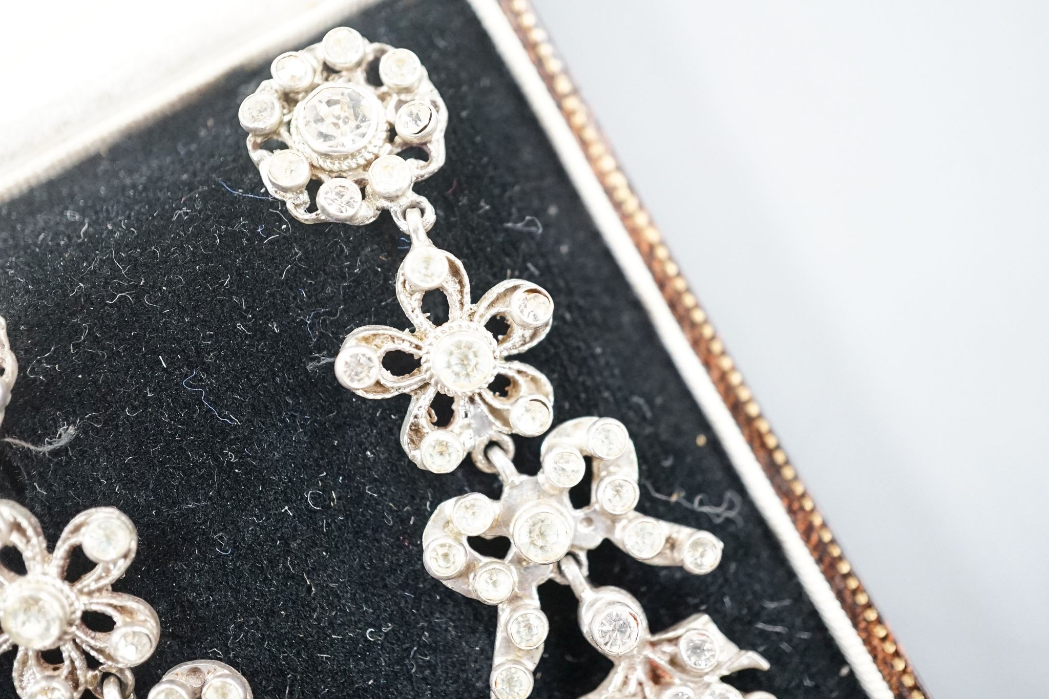 A pair of white metal and two colour paste drop earrings, 68mm, in a gilt tooled leather box.